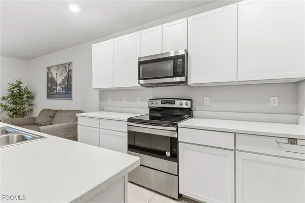 a kitchen with stainless steel appliances a stove microwave and sink