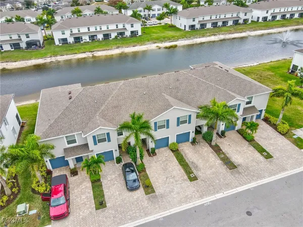 an aerial view of residential houses with outdoor space and lake view