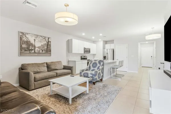 a living room with furniture and kitchen view