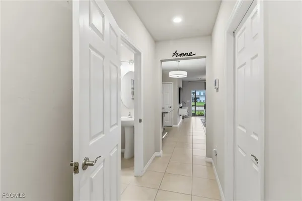 a view of a hallway with wooden floor and a bathroom