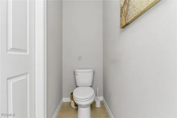 a white toilet sitting next to a white wall