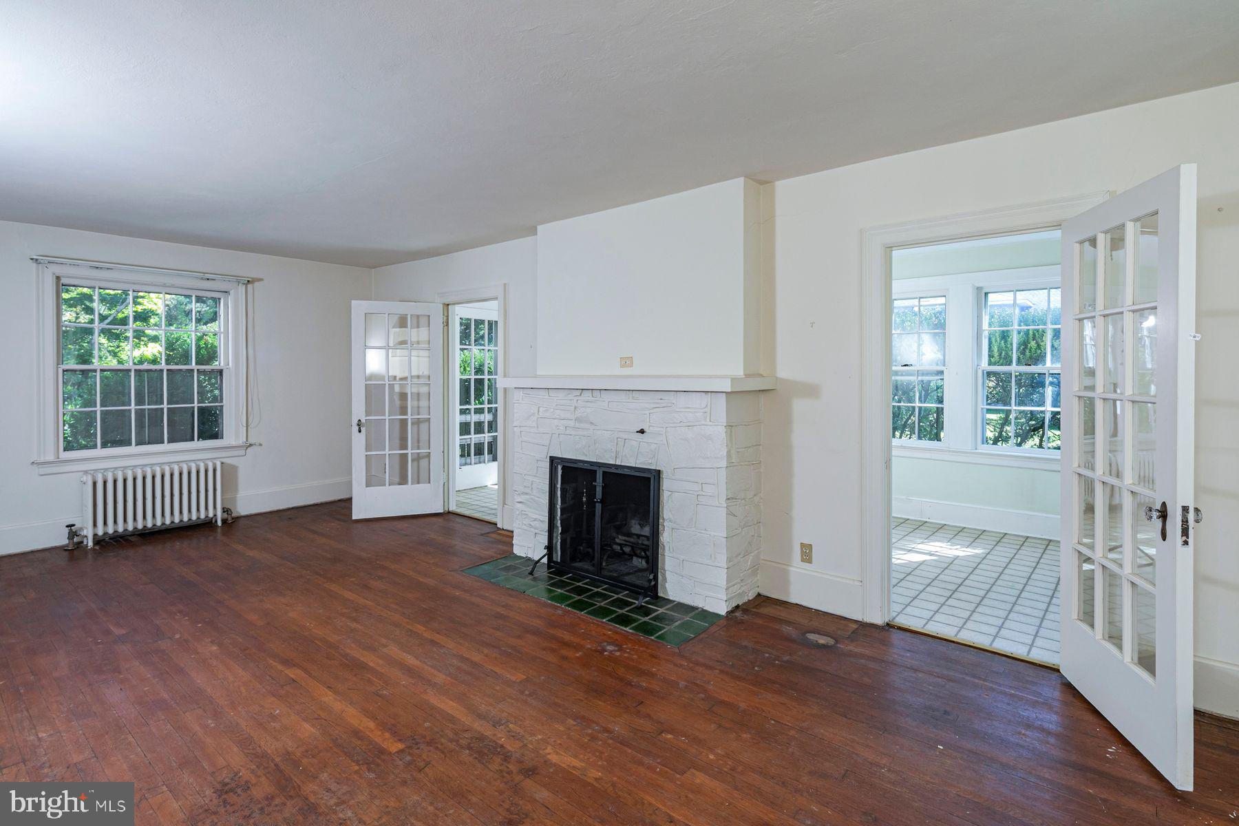 158 Carter Road Princeton, NJ 08540 - Photo 6 of 29 an empty room with wooden floor fireplace and windows