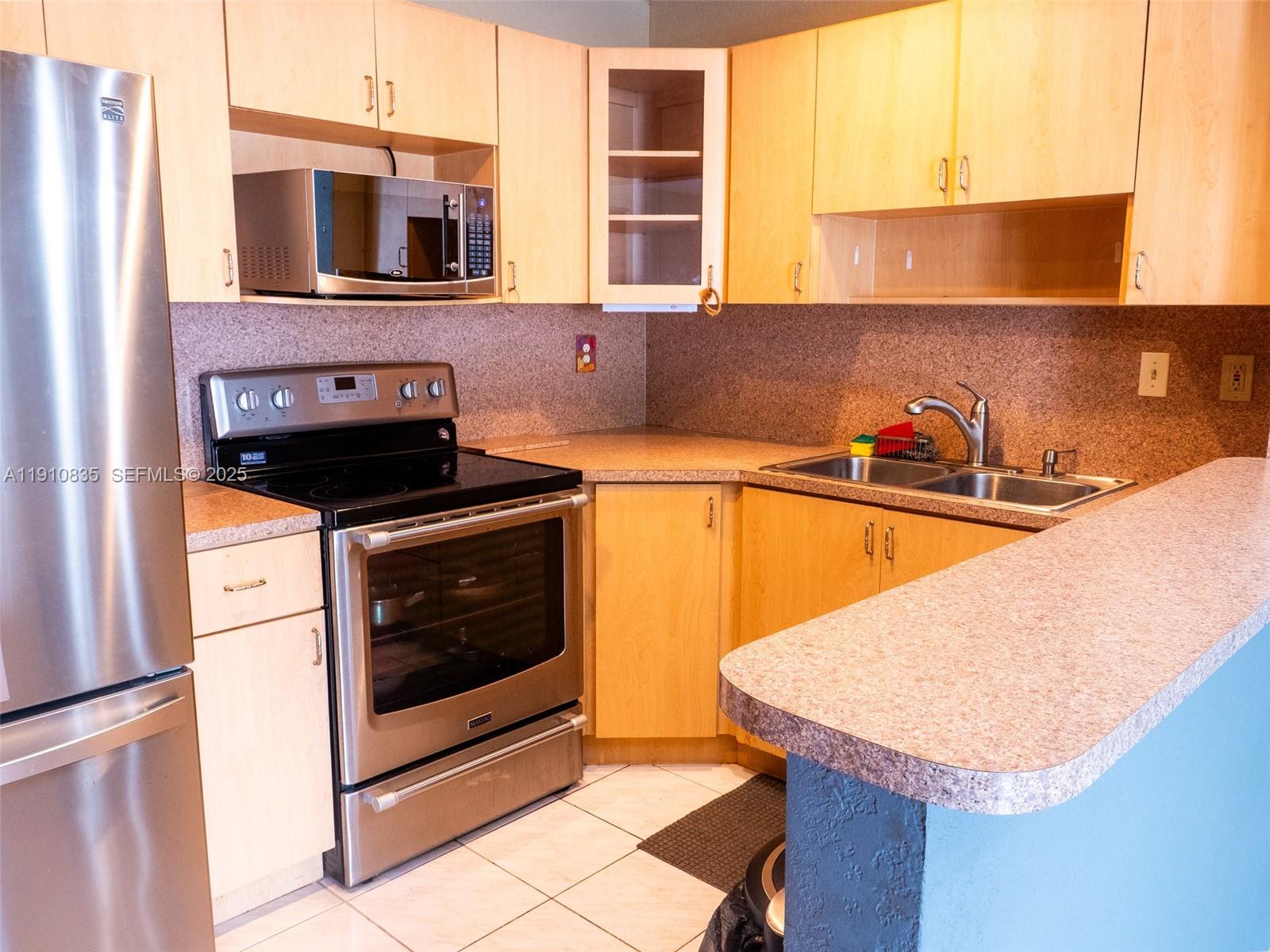 a kitchen with a sink a microwave and window