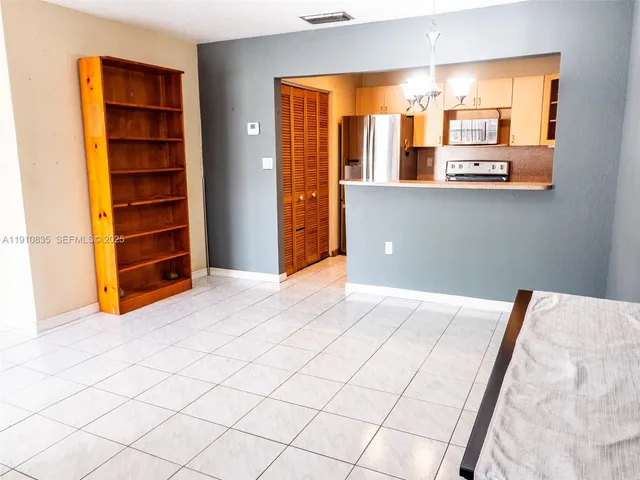 a view of an empty room with cabinet and a window