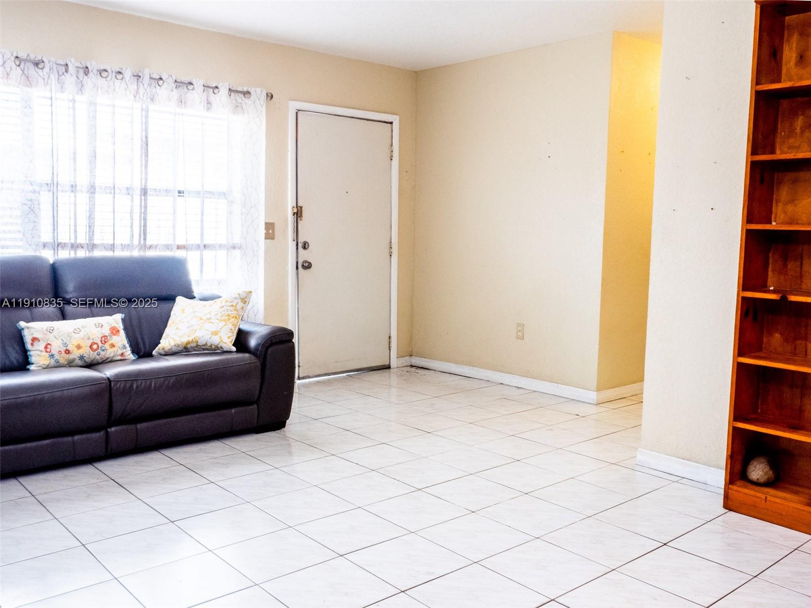 13241 Southwest 17th Lane, Unit 234 Miami, FL 33175 - Photo 5 of 16 a living room with furniture and a book shelf