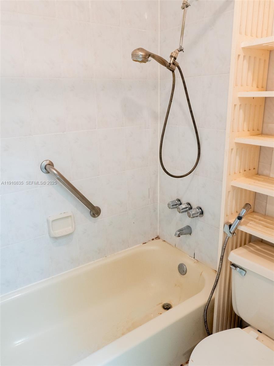 13241 Southwest 17th Lane, Unit 234 Miami, FL 33175 - Photo 10 of 16 a bathroom with a bath tub a toilet and a shower