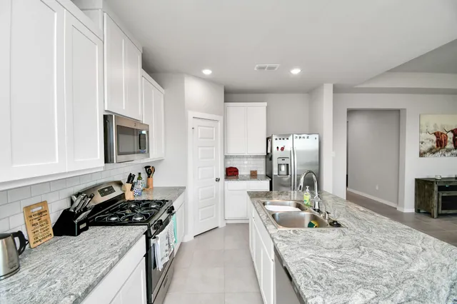 a large kitchen with a stove a sink and a refrigerator