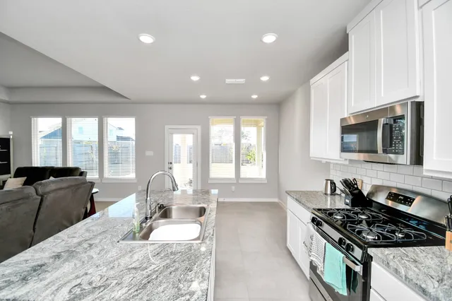 a kitchen with stainless steel appliances granite countertop a stove and a sink