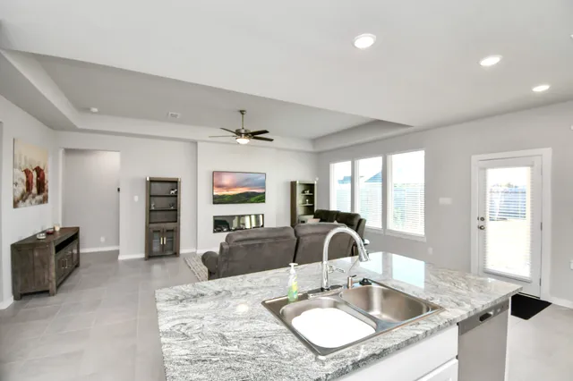 a kitchen with granite countertop a sink and a refrigerator