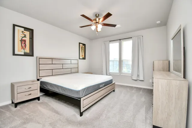 a bedroom with a bed and a large window