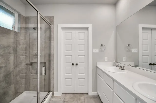 a bathroom with a shower sink and mirror