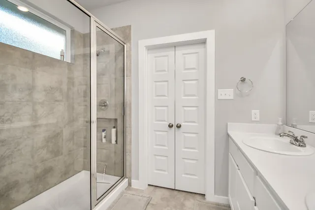 a bathroom with a shower sink and mirror