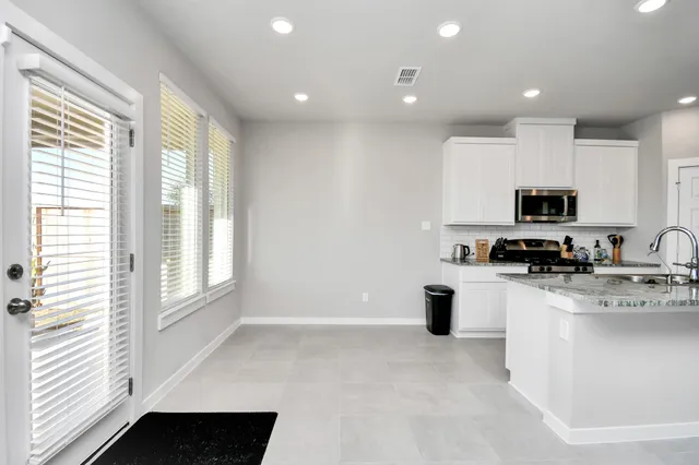 a kitchen with a sink a counter top space cabinets and stainless steel appliances