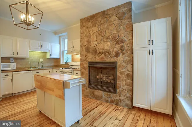 a kitchen with a stove and wooden floor