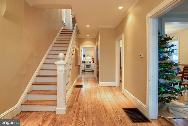 a view of a hallway with wooden floor and staircase