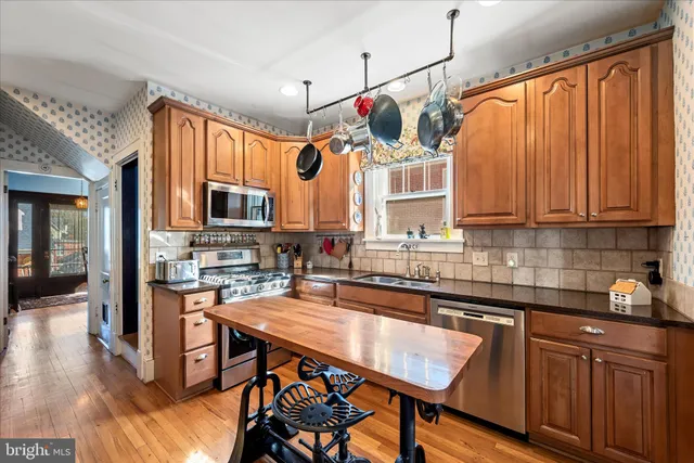 a kitchen with stainless steel appliances granite countertop a refrigerator and a stove