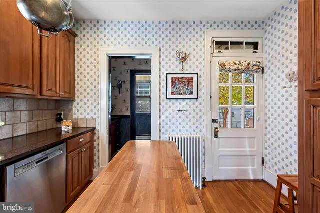 a view of a dining room and livingroom with furniture wooden floor a rug a flat screen tv a rug and a chandelier