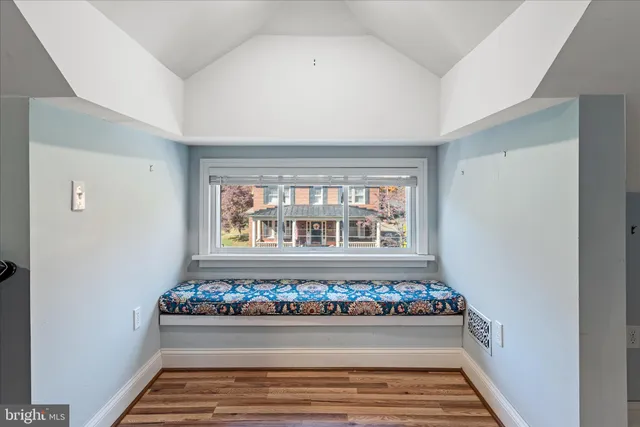 a balcony with table and chairs and potted plants
