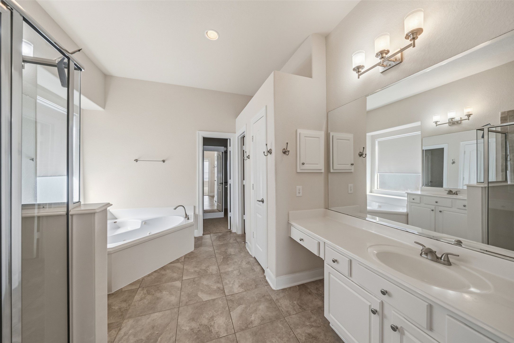 25802 Northcrest Drive Spring, TX 77389 - Photo 15 of 28 a spacious bathroom with a double vanity sink a mirror a bathtub and shower