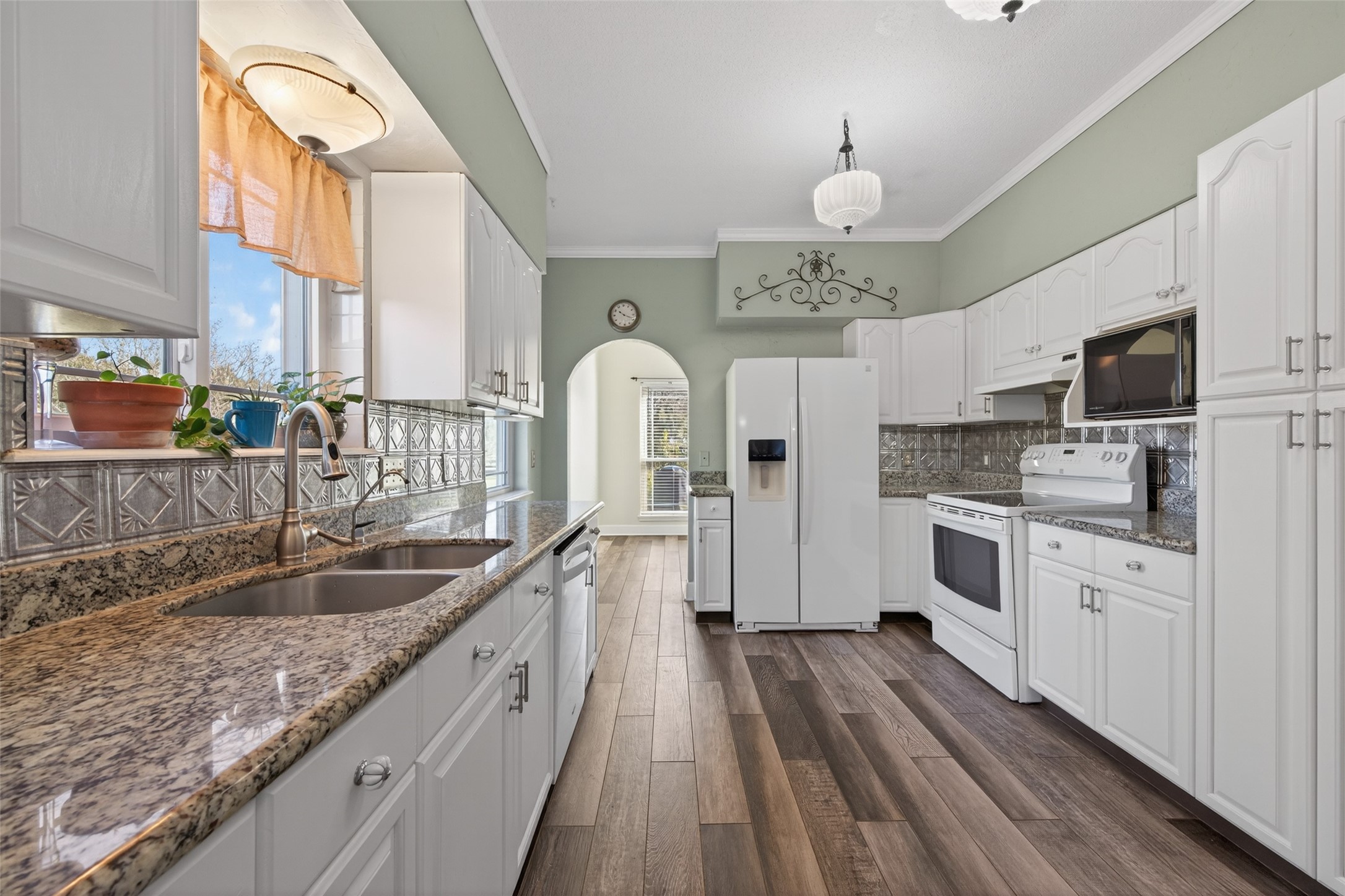 6610 Sprigg Street Fulshear, TX 77441 - Photo 14 of 41 a kitchen with stainless steel appliances granite countertop a sink dishwasher a stove and white cabinets with wooden floor