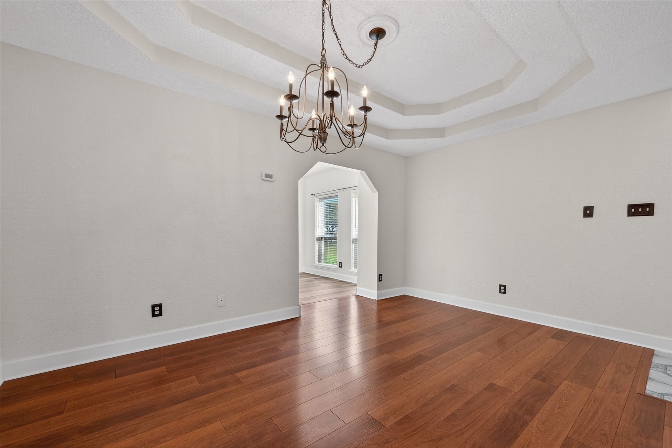 6610 Sprigg Street Fulshear, TX 77441 - Photo 5 of 41 a view of a room with wooden floor and chandelier