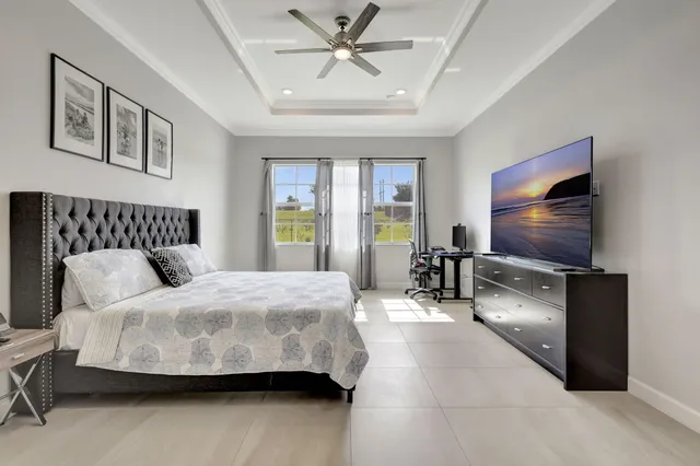 a bedroom with a bed and a flat tv screen on dresser