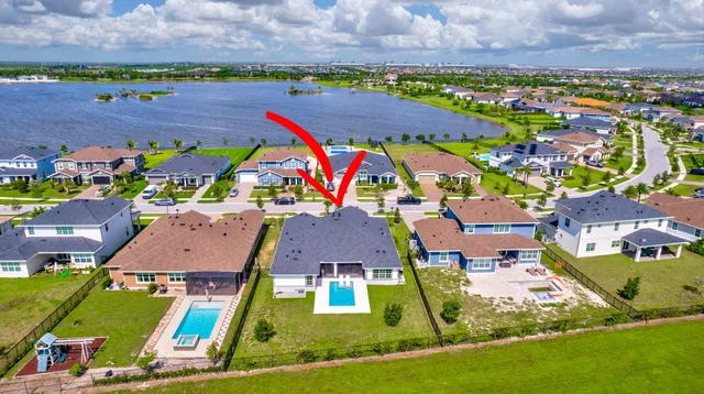 an aerial view of a house with a yard and lake view