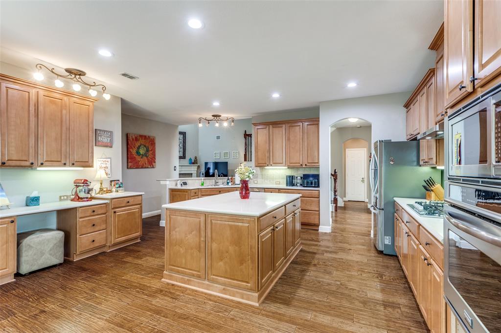 14886 Daneway Drive Frisco, TX 75035 - Photo 11 of 30 a large kitchen with stainless steel appliances kitchen island granite countertop a stove and a sink