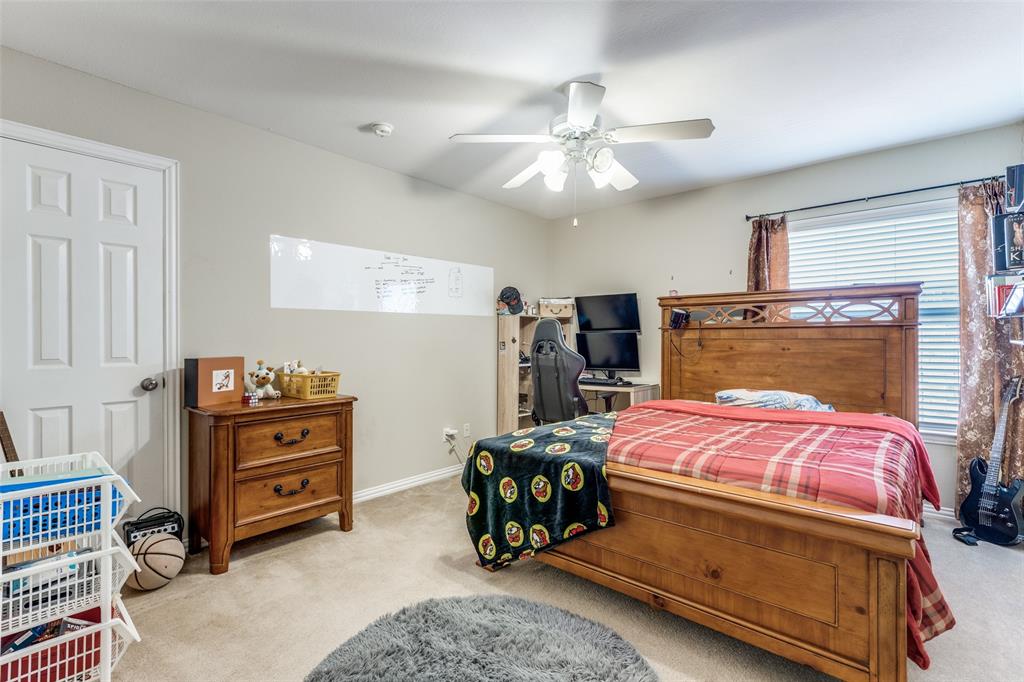 14886 Daneway Drive Frisco, TX 75035 - Photo 17 of 30 a bedroom with a bed and a chandelier