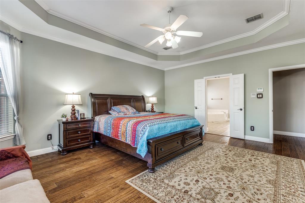 14886 Daneway Drive Frisco, TX 75035 - Photo 22 of 30 a bedroom with a bed and a chandelier