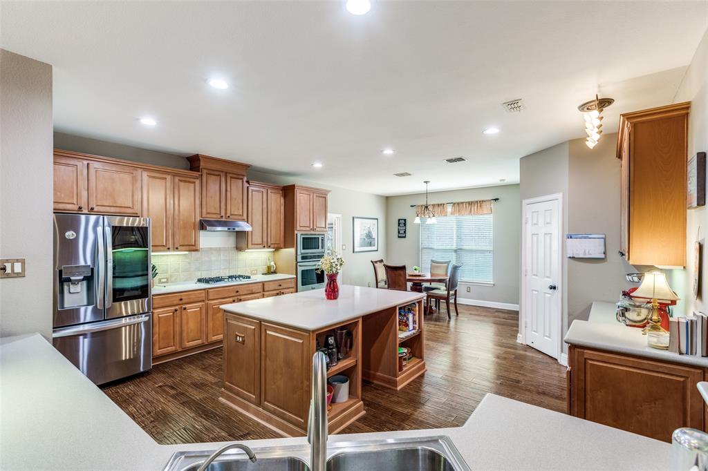 14886 Daneway Drive Frisco, TX 75035 - Photo 9 of 30 a large kitchen with kitchen island a sink counter space and stainless steel appliances