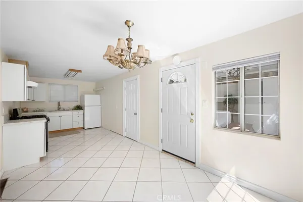 a view of a kitchen with cabinet and refrigerator