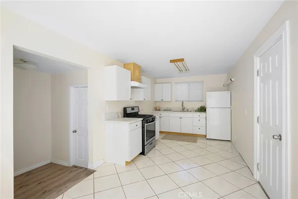 a kitchen with white cabinets and white appliances