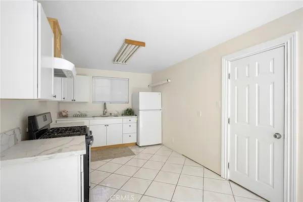 a kitchen with a stove a refrigerator and cabinets