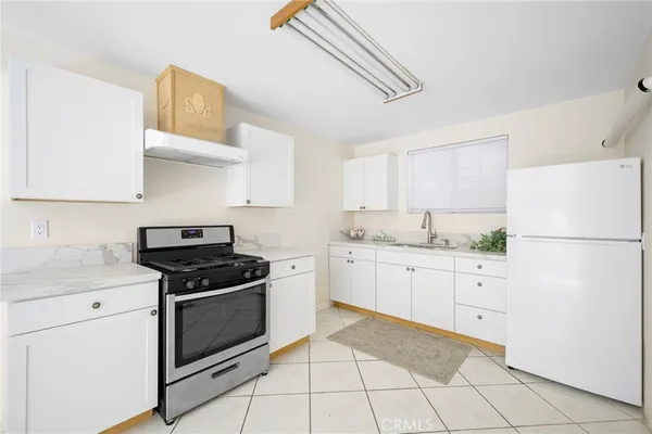 a kitchen with white cabinets appliances and sink
