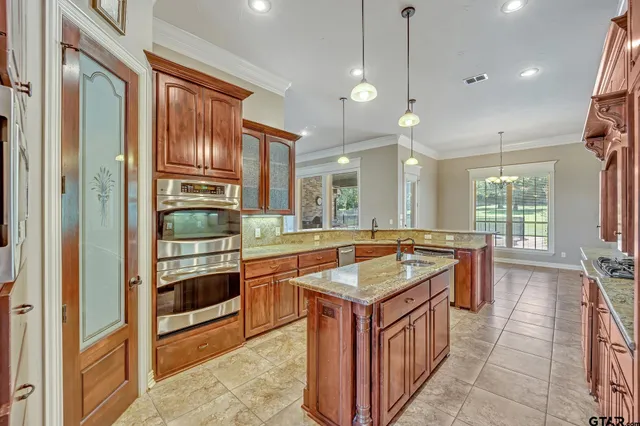 a kitchen with stainless steel appliances granite countertop a sink and a refrigerator