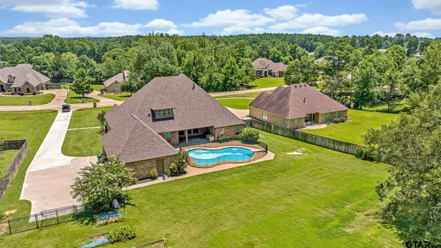 an aerial view of a house with swimming pool and mountains
