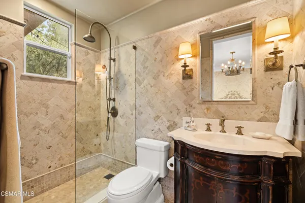 a spacious bathroom with a granite countertop sink a mirror a vanity and shower