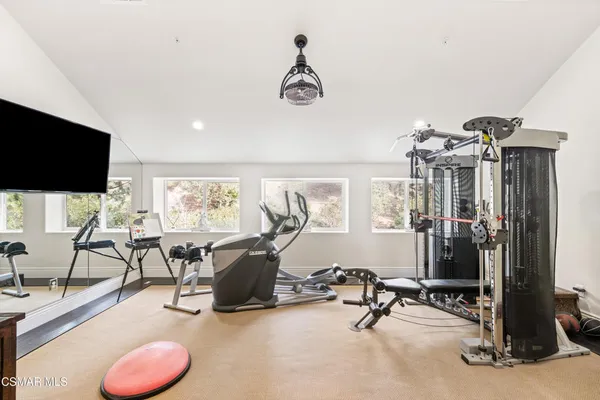 a bedroom with a bed a flat screen tv and a chandelier