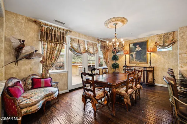 a living room with furniture a chandelier and a flat screen tv