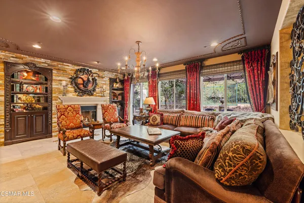 a living room with patio furniture and a chandelier