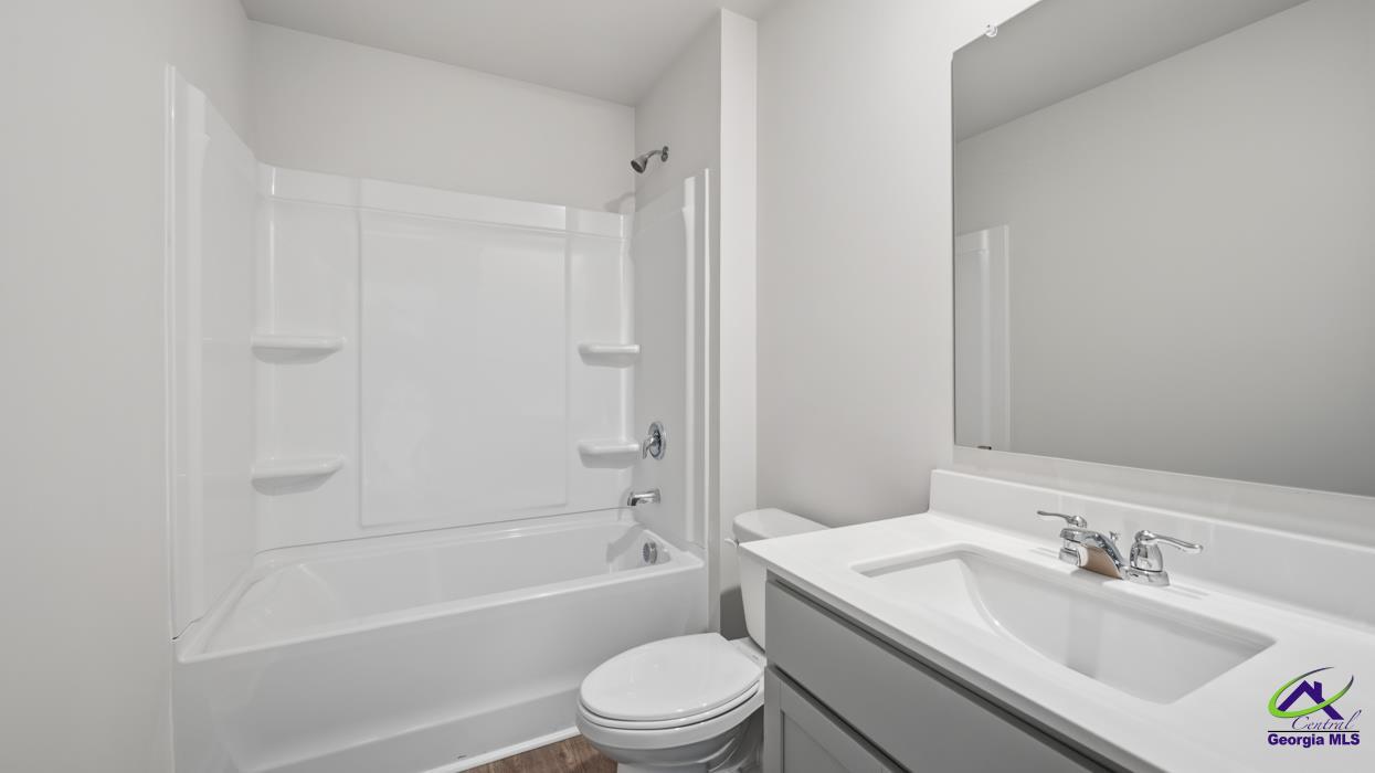 227 Cattle Drive Perry, GA 31069 - Photo 31 of 40 a bathroom with a granite countertop bathtub shower sink vanity mirror and toilet