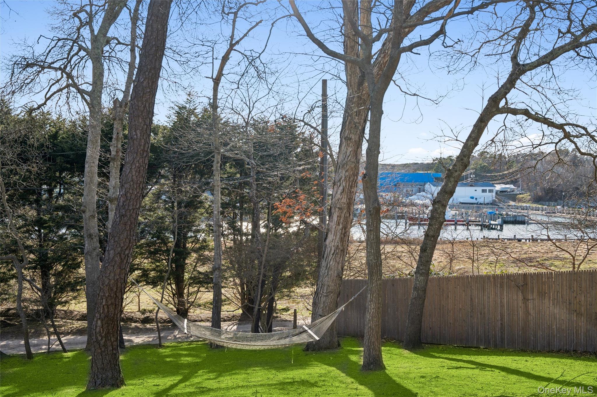6 Private Row Hampton Bays, NY 11946 - Photo 14 of 14 a view of a backyard with large trees