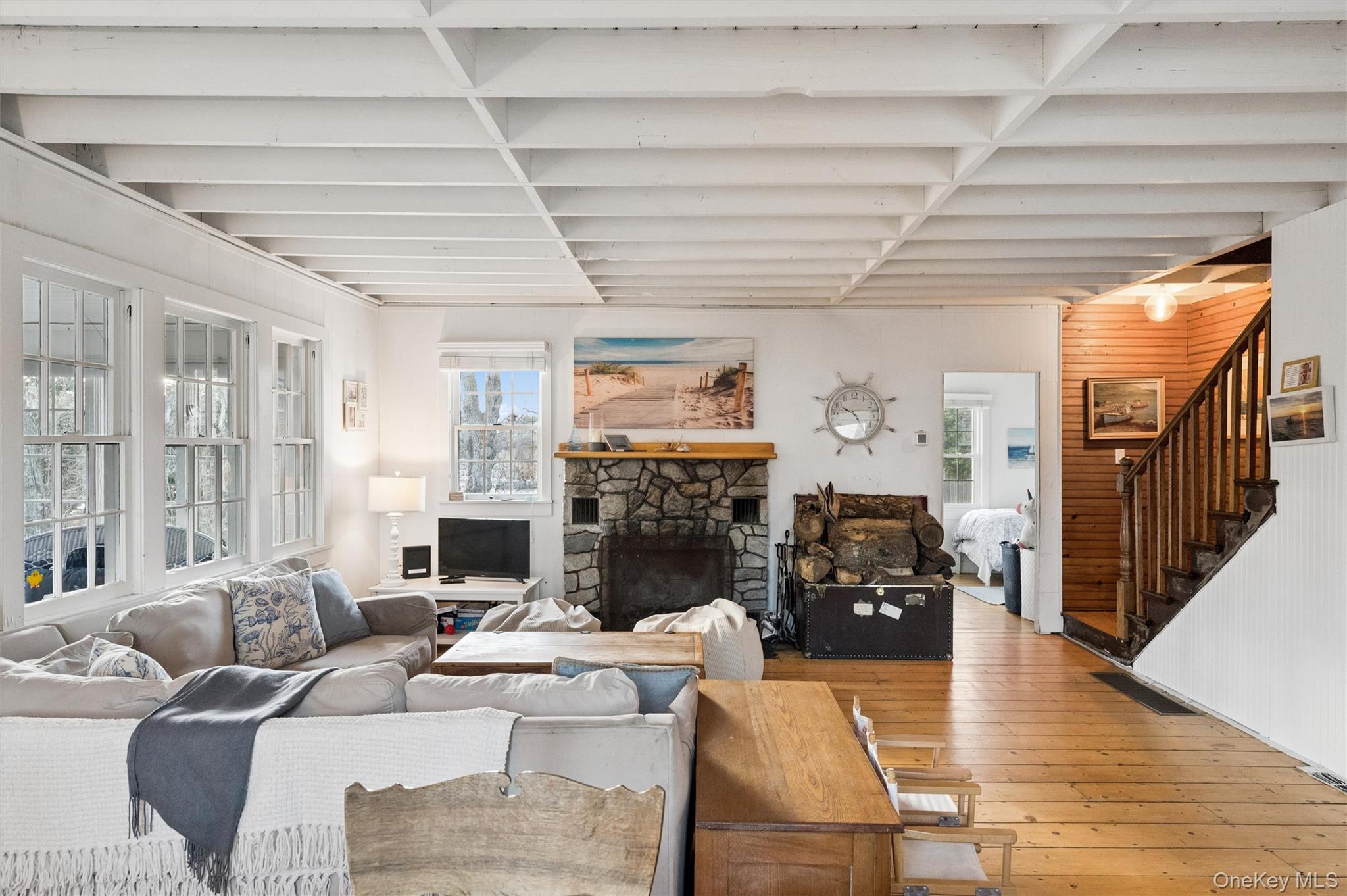 6 Private Row Hampton Bays, NY 11946 - Photo 7 of 14 a living room with furniture large wooden floor and a fireplace