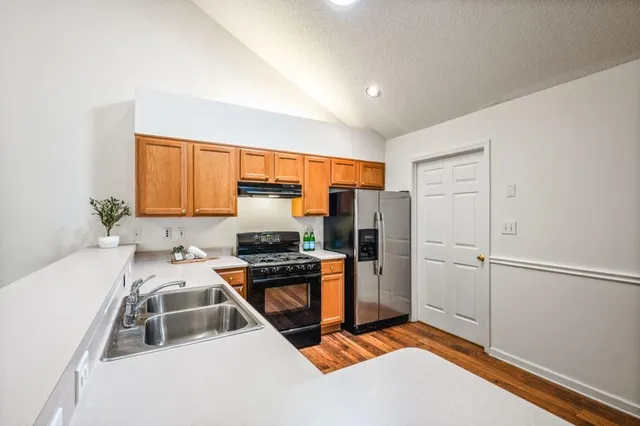 a kitchen that has a sink cabinets and stainless steel appliances