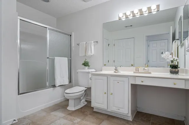 a spacious bathroom with a double vanity sink toilet and a mirror