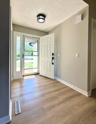 an empty room with windows and chandelier fan