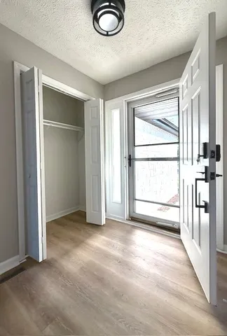 an empty room with windows and fan