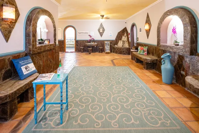 a bedroom with a bed a table and a flat screen tv