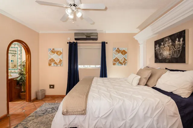 a spacious bedroom with a bed and a flat screen tv